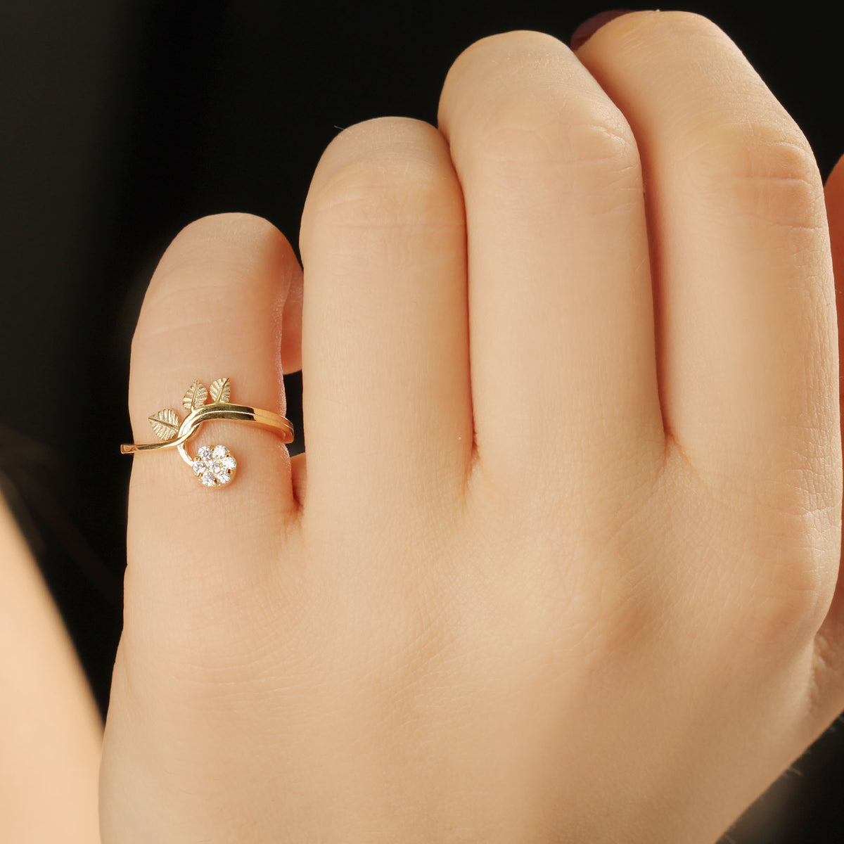 14K gold cluster leaf diamond ring on raised hand