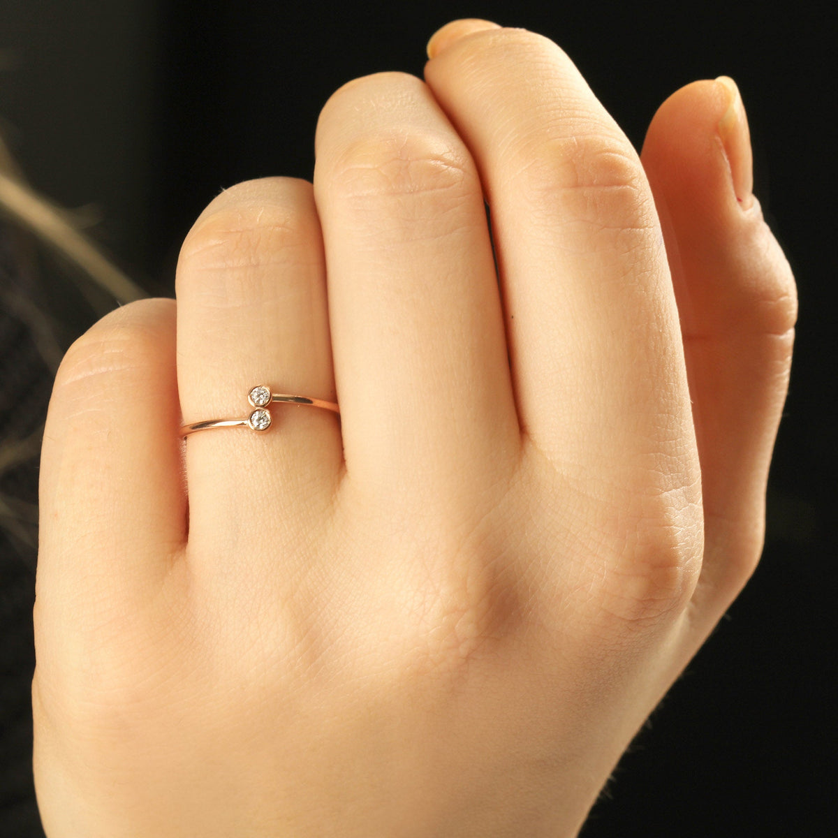 18K gold toi et moi bezel diamond ring on raised hand