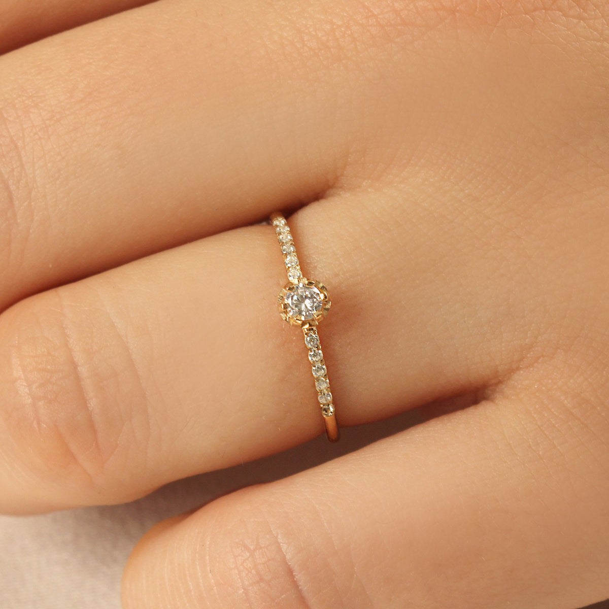 18K gold solitaire engagement cubic zirconia ring worn on hand, side view