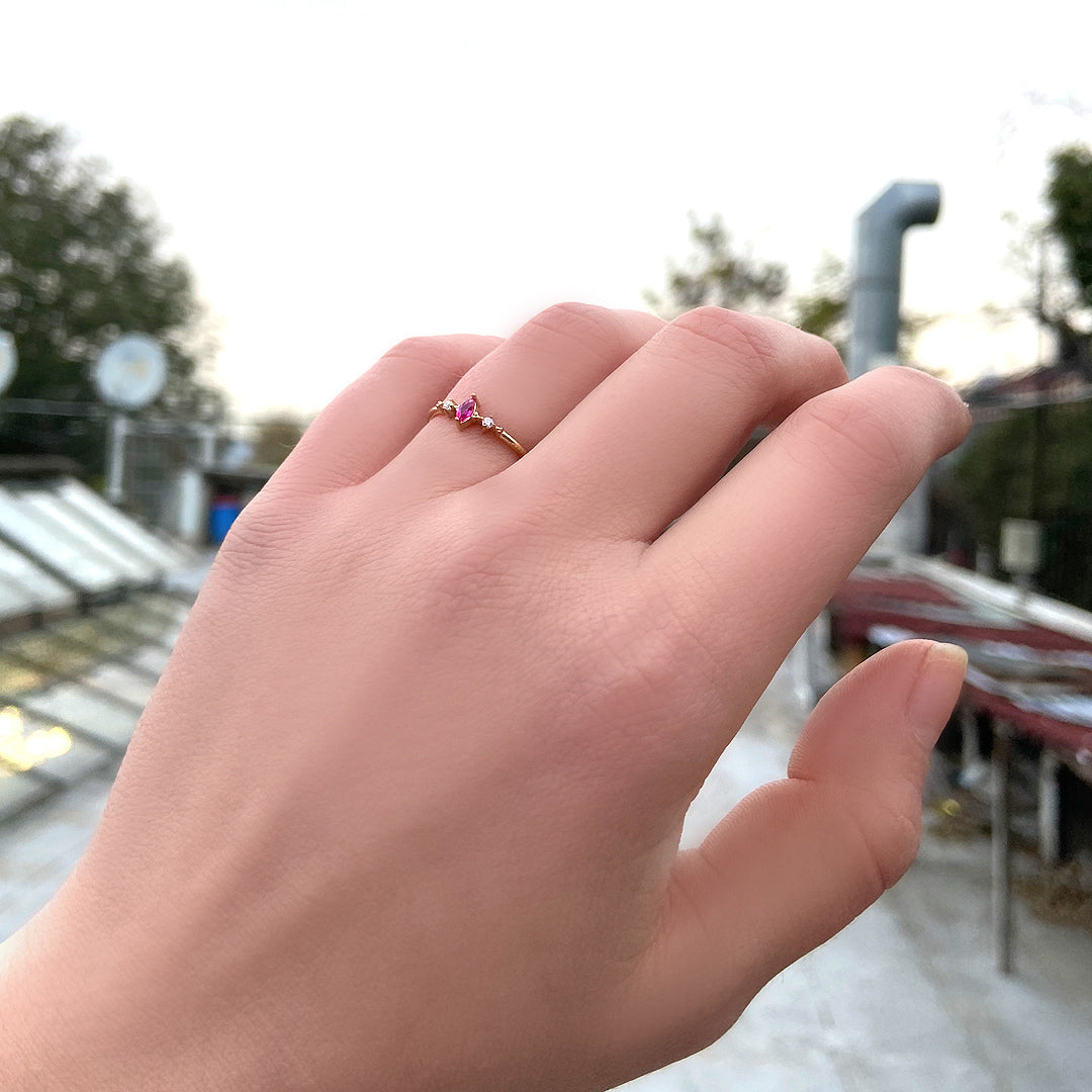 18K gold red-stone marquise cubic zirconia ring on finger, close-up