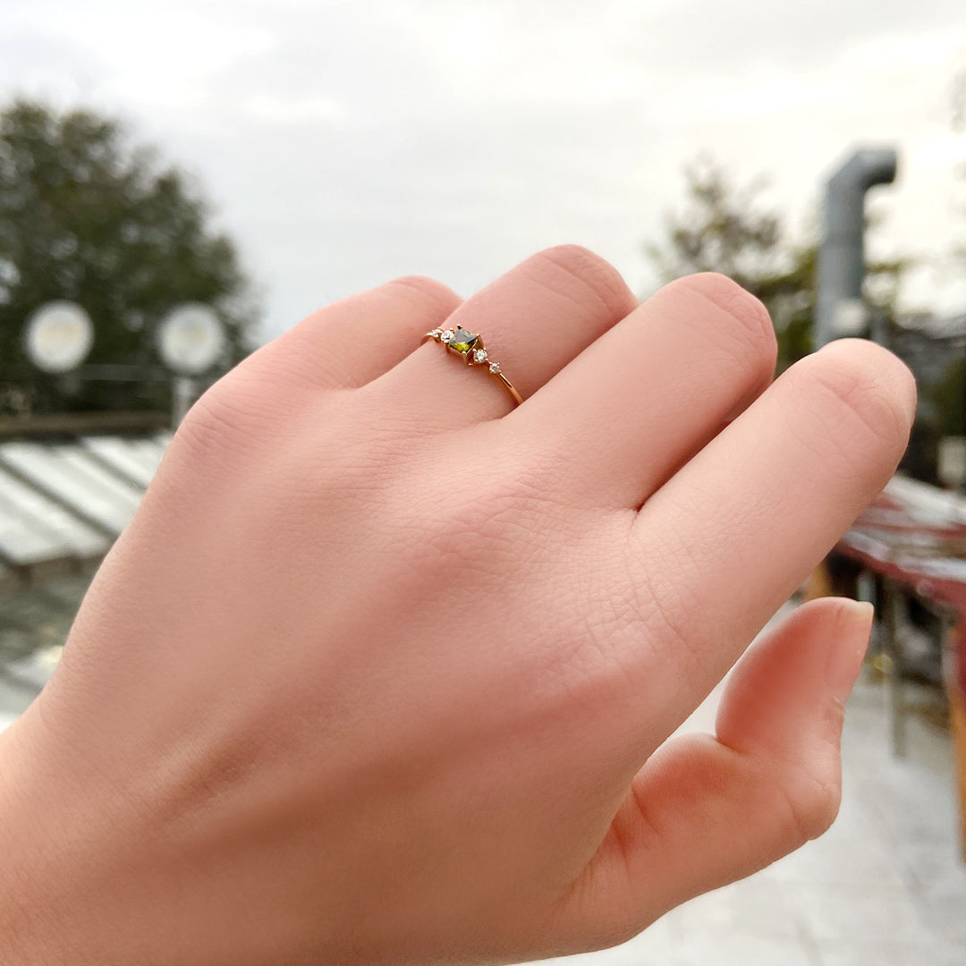 14K gold green-stone princess diamond ring worn on hand, side view