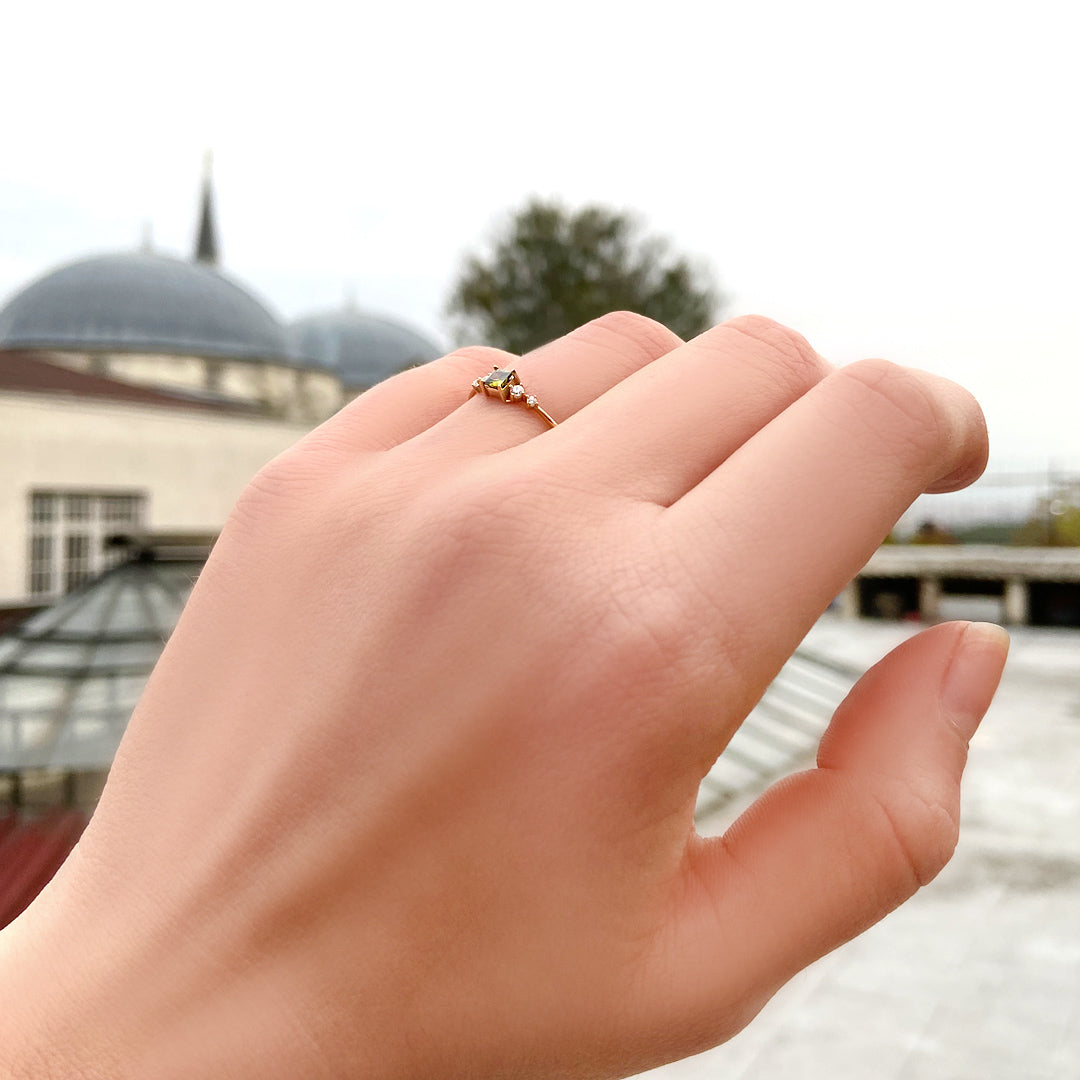 18K gold green-stone princess cubic zirconia ring on raised hand
