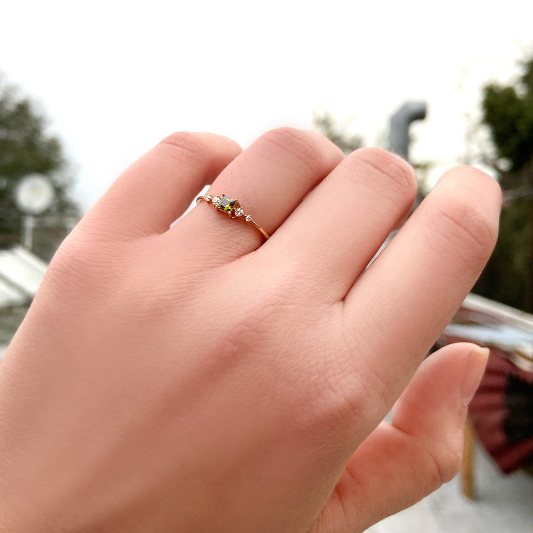 10K gold green-stone princess diamond ring worn on hand